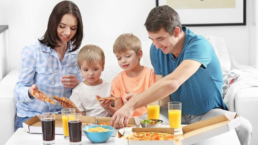 young family with children eating pizza
