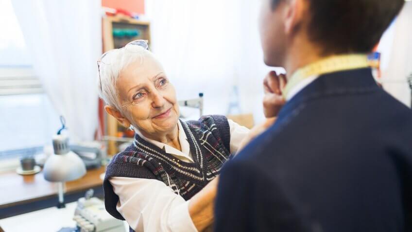 older senior woman tying mans tie