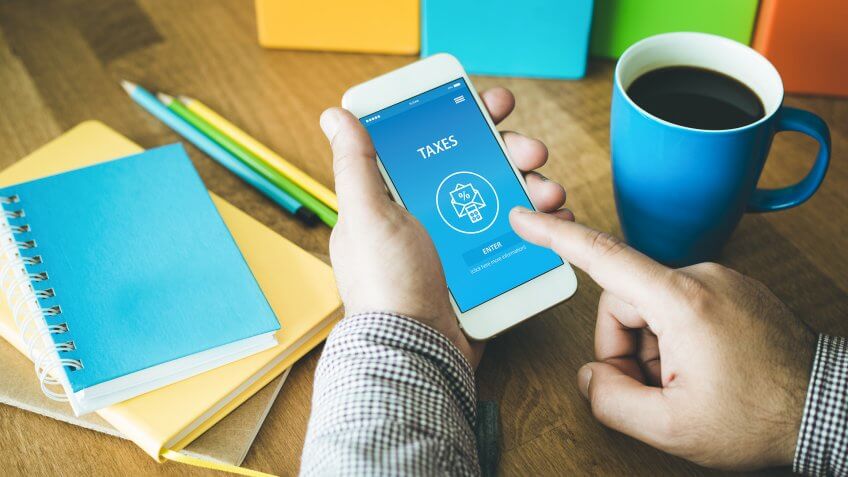 man checking taxes on his smartphone