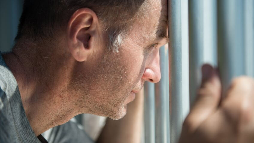 man looking through blinds