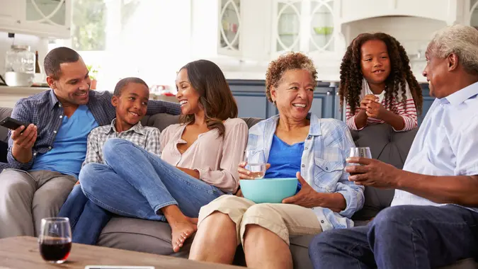 Family sitting on the couch drinking water and wine