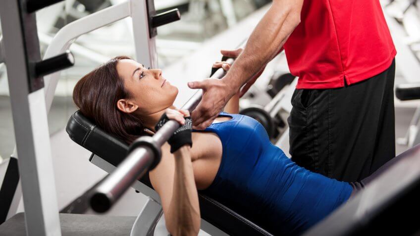 woman working out with a man spotting her