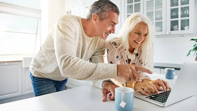 happy middle aged couple using laptop