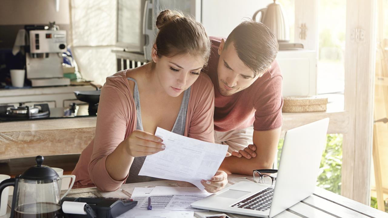 young couple at home reviewing paperwork