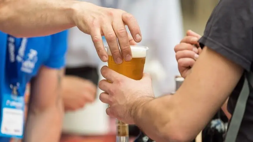 worker handing a customer beer