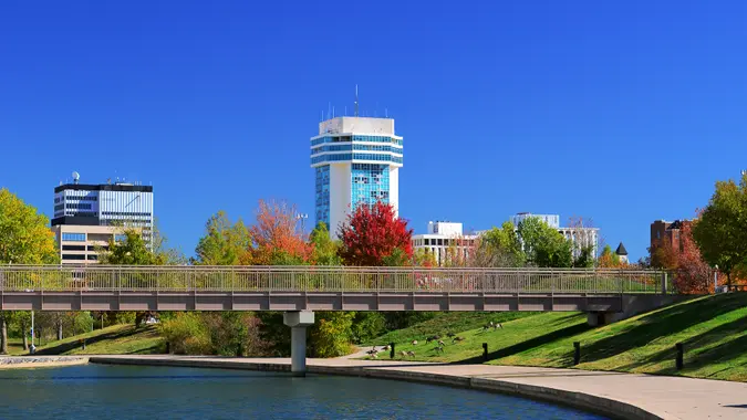 Downtown Wichita skyline with a waterway and park in the foreground.