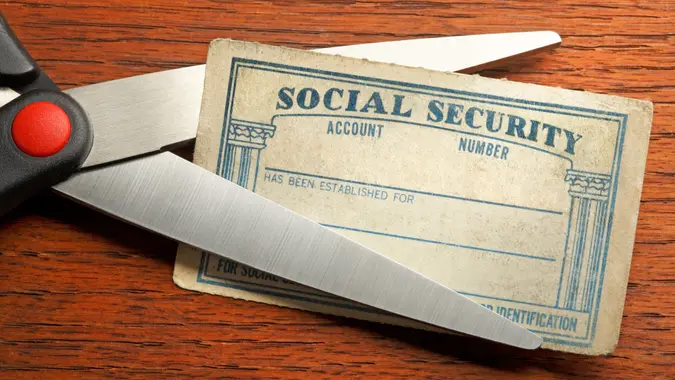 A pair of scissors about to cut a blank Social Security card