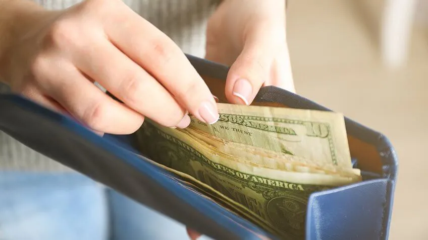 person about to pull $10 from wallet