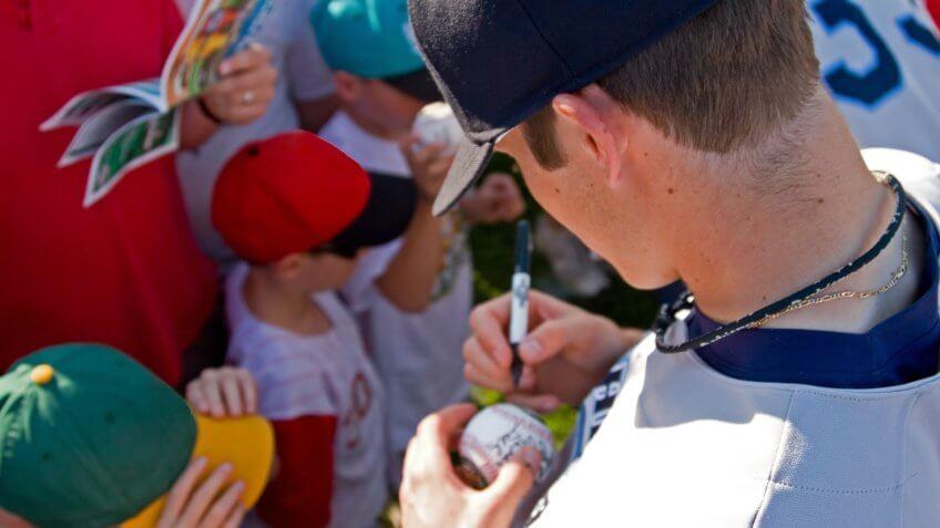 baseball player autographing signing a ball