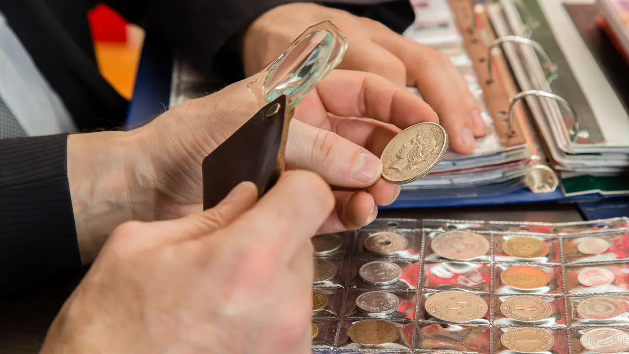 coin inspector using a magnifying glass to examine a coin