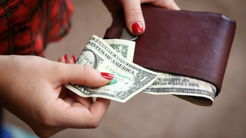 Woman with one dollar bill in wallet
