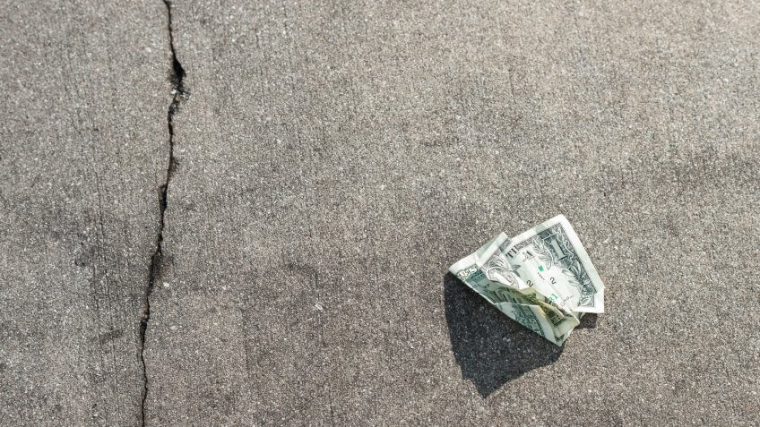 US Dollar Bill in on Concrete Sidewalk.