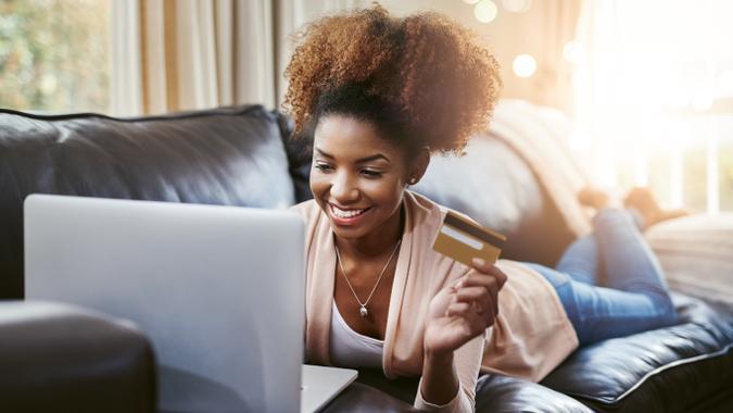 woman using gold credit card while browsing online