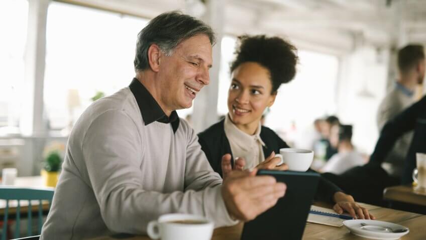 older man having coffee with a young woman