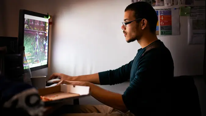 young male tendie investor using computer to play video games