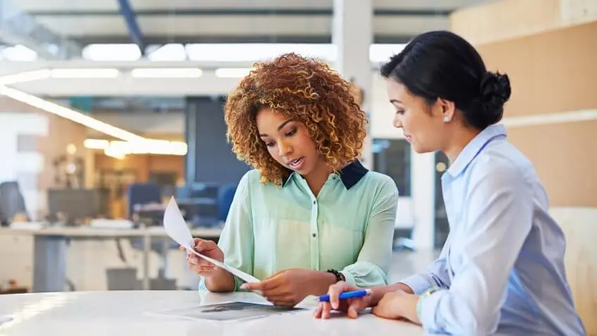 two women in a library discussing finances
