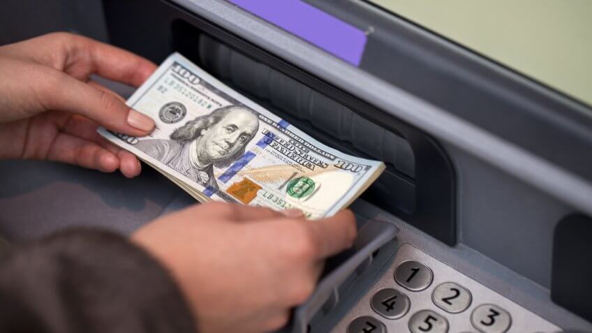 man depositing money in ATM man depositing money in ATM