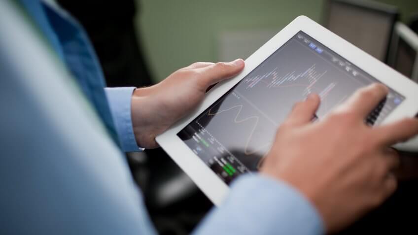 man with investment on tablet man with investment on tablet