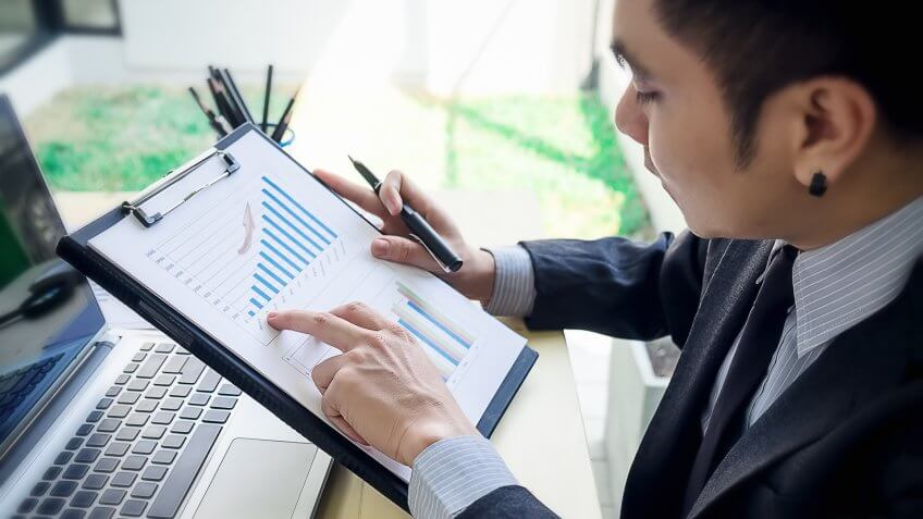 man with graph of financials man with graph of financials