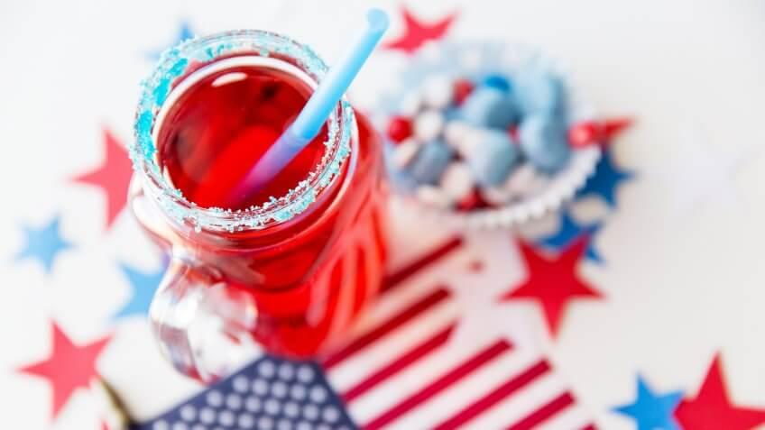 6 Red, White and Blue Batch Cocktails for Under $12, american independence day, celebration, flag and candies at 4th july party, patriotism and holidays concept - close up of juice glass