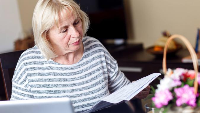 You Need to Pay Down Debt senior-woman-reviewing-earnings-record