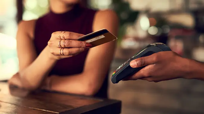 Closeup shot of a woman paying using NFC technology in a cafe.