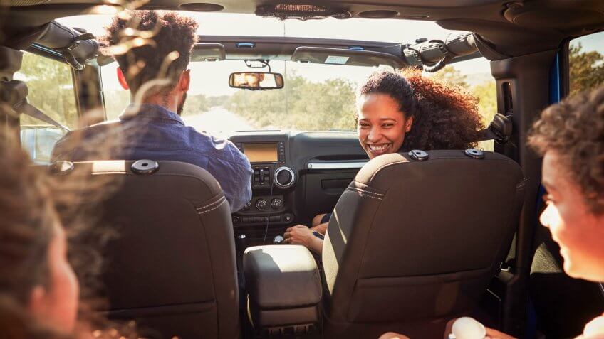Excited family on a road trip in car, The Best and Worst Things to Buy in August 2017, rear passenger POV