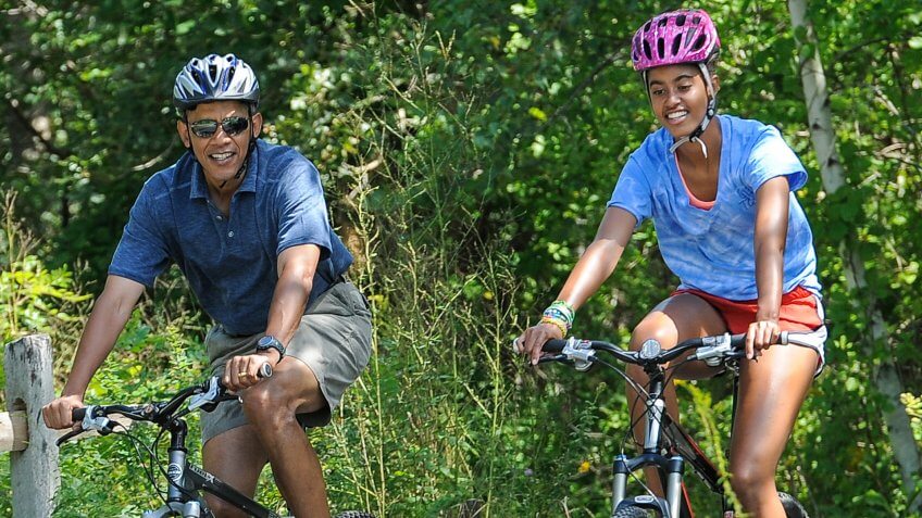 Barack Obama riding a bike with daughter