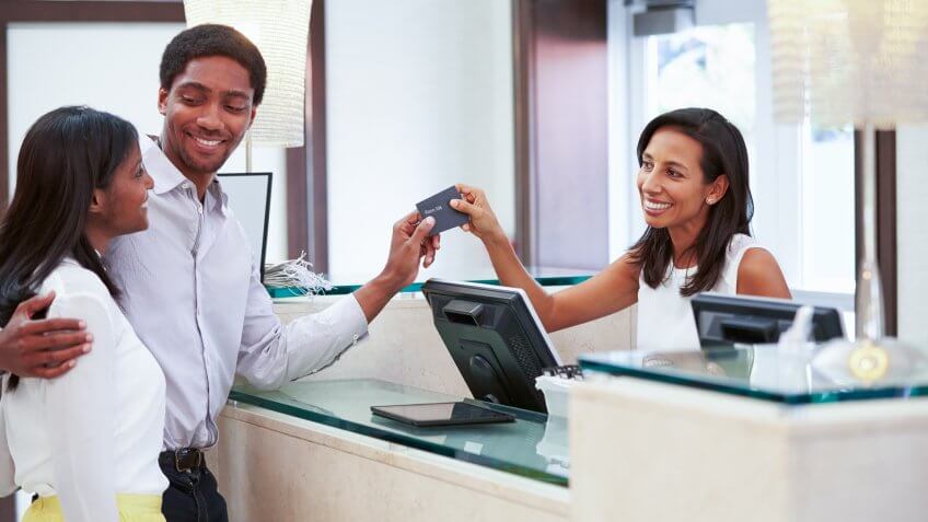 Couple Checking In At Hotel Reception, Free Hotel Upgrades That You're Missing Out On