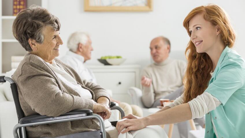 22 Industries That Pay Less (and More) Than They Did 10 Years Ag, Nurse taking care of senior woman on wheelchair