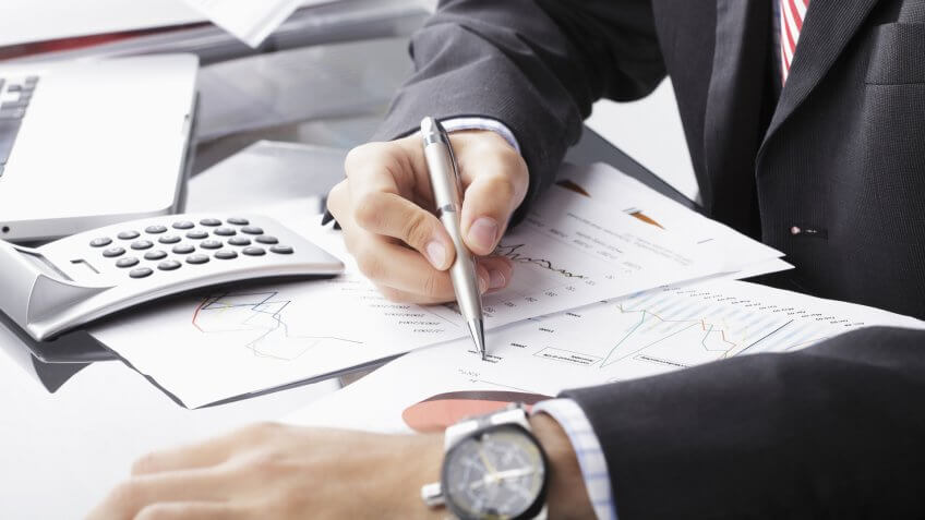 22 Industries That Pay Less (and More) Than They Did 10 Years Ag, Close-up photo of a businessman analyzing financial data