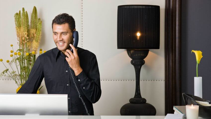 25-30 years, Adult, Caucasian, Computer, Europe, Free Hotel Upgrades That You're Missing Out On, Lamp, Listening, Modern, Occupation, Technology, Telephone, Young Adult, answering, bazzano, booking, brunette, communication, concierge, counter, customer service, european, front desk, front view, half-length, happy, holding, hotel, indoor, italy, landline, man, one person only, phoning, planning, reception desk, receptionist, service, smiling, standing, talking, vacation