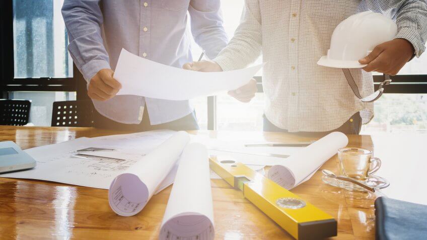 22 Industries That Pay Less (and More) Than They Did 10 Years Ag, Architects concept, Architects working with blueprints in the office
