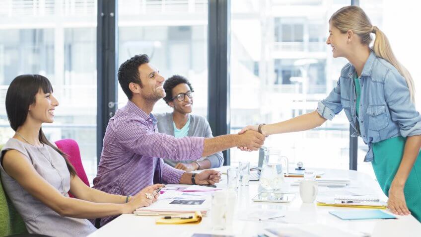 Business people shaking hands in meeting.