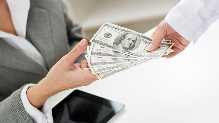 Close-up of female hand giving money.