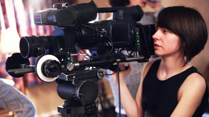 "Filming, 101 Money-Making Skills You Can Learn in Less Than a Year, Arts And Entertainment, Camera, Caucasian, Cinema, Concentration, Director, Expertise, Film, Film Industry, Film Reel, High-definition Television, Human Face, Industry, Looking, Mattebox", Movie, Occupation, Operator, Photography Themes, Professional Occupation, Single Object, Teamwork, Technology, Video, Viewfinder, Working, Young Adults, Young Women, aiming, contemplation, lifestyle, outdoors, people, photography, serious, women