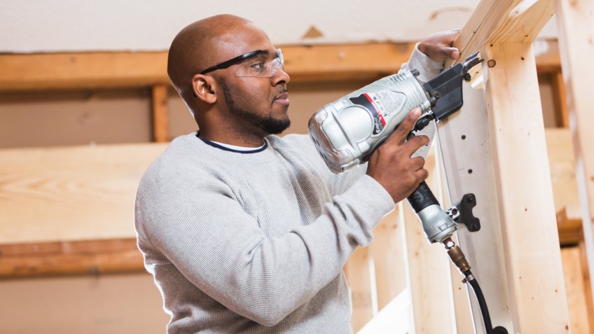 96 Money-Making Skills You Can Learn in Less Than a Year, 40-49 Years, African Descent, Building - Activity, Building Contractor, Built Structure, Casual Clothing, Construction Frame, Construction Industry, Construction Site, Construction Worker, Head And Shoulders, Home Addition, Home Interior, Industry, Inside Of, Males, Manual Worker, Minority, Occupation, One Person, Portrait, Power Tool, Protective Eyewear, Residential Building, Shaved Head, Stud, Wood - Material, Work Tool, Working, african ethnicity, home improvement, horizontal, house, indoors, mature adult, men, people, serious, standing