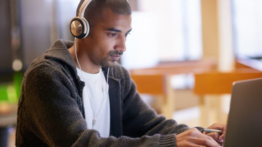 96 Money-Making Skills You Can Learn in Less Than a Year, 20-29 Years, Adult, Adults Only, Attractive Male, Attractive Man, Blank Expression, Casual Clothing, Cheerful, Comfortable, Computer, Confidence, E-Mail, Ethnic, Focus - Concept, Happiness, Headphones, Inside Of, Internet, Learning, Lifestyles, Listening, Looking, Males, Modern, Music, One Man Only, One Young Man Only, Only Men, Part Of, Real People, School Building, Stubble, Surfing the Net, Technology, Typing, Web Page, Working, Young Adult, Young Men, Youth Culture, campus, education, headset, indoors, laptop, men, people, relaxation, sitting, student, support, university, university student, using computer