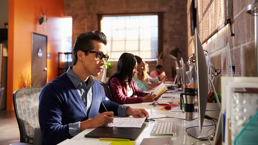 96 Money-Making Skills You Can Learn in Less Than a Year, Designers Working At Desks In Modern Office