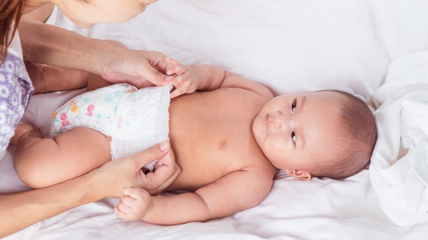 mom changing baby diapers
