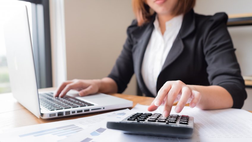 96 Money-Making Skills You Can Learn in Less Than a Year, Asian female accountant or banker making calculations. Savings, finances and economy concept.