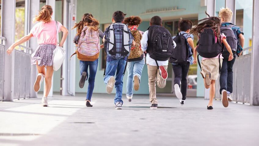 students with backpacks running in school