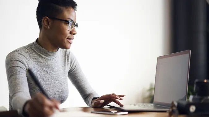 96 Money-Making Skills You Can Learn in Less Than a Year, Young afro american female executive filling in application on o