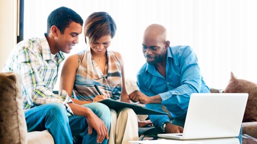 Young African couple in a meeting with a financial advisor signing documents.