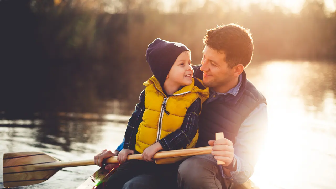 Dad and son enjoying canoe ride on a beautiful sunny day,.