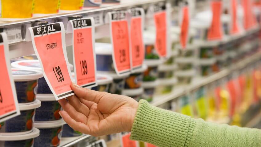 Checking price of item in supermarket aisle.