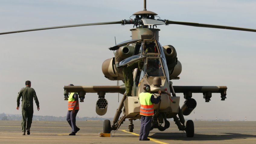 Maintenance crew helping the pilots get out of the helicopter.