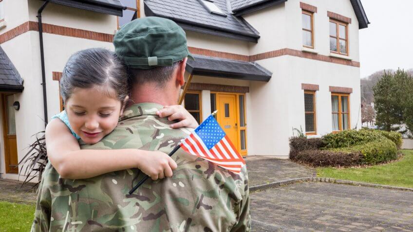 Composite images of American soldier carrying girl in front of a house.