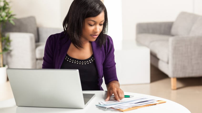 Attractive young African American woman working on finances at h, Secret Tips to Live a Financially Secure Life