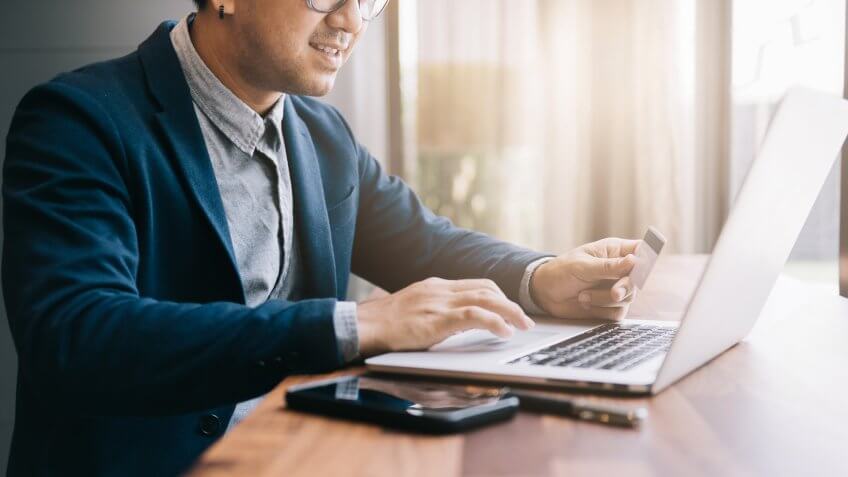shopping online concept , businessman shopping online with computer laptop and credit card on vintage tone.
